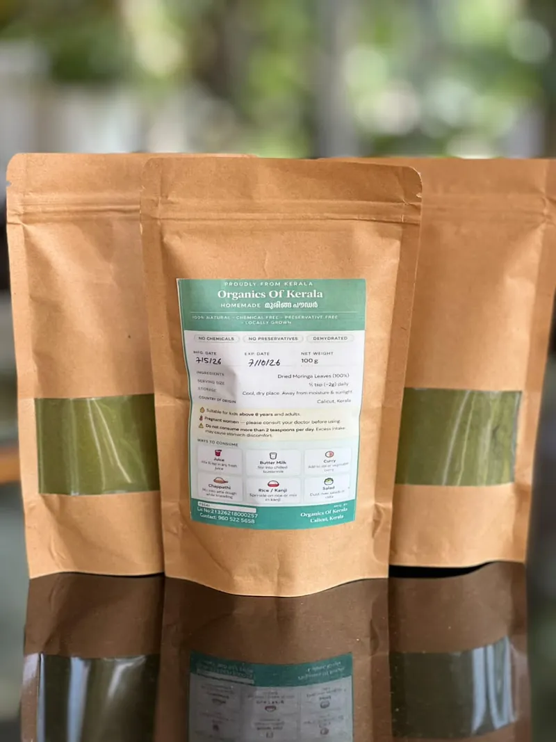 Three kraft pouches of muringa powder, each with a window showing the green powder inside